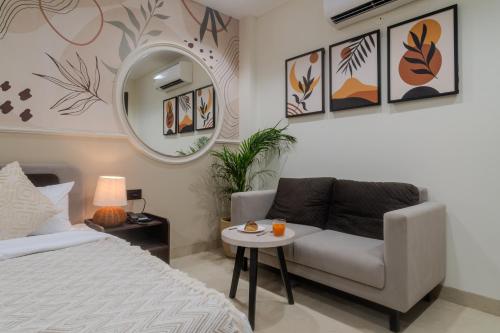 a bedroom with a bed and a chair and a mirror at One Stayz by Zipcode in Gurgaon