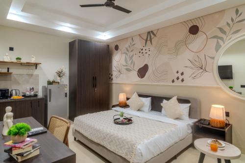 a bedroom with a bed and a table and a kitchen at One Stayz by Zipcode in Gurgaon