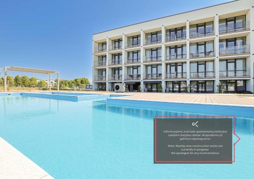 a building with a large pool in front of it at Studio W/Balcony @ManoŠventovė, By Cohost in Palanga