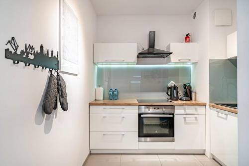 een keuken met witte kasten en een fornuis bij MiCasaEsSuCasa with free parking! in Gdańsk