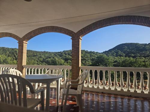 a balcony with a table and chairs and mountains at Casa Rural Los Chorros de Joyarancón in La Presa