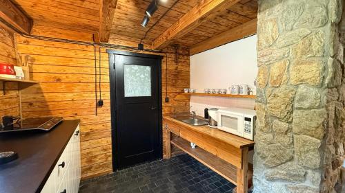 a kitchen with a black door and a microwave at Chatka Trapera in Bielice