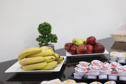 two trays of bananas and apples on a table at أوتار ذهب للشقق الفندقية الفاخرة in Ma‘ān