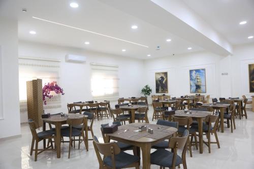 a dining room with wooden tables and chairs at أوتار ذهب للشقق الفندقية الفاخرة in Ma‘ān