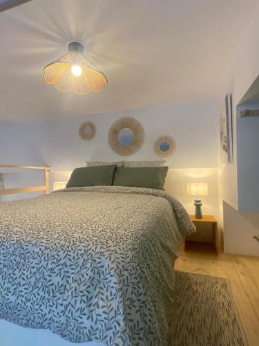 a bedroom with a bed with a blue and white comforter at Le nid d'Ambre in Étaples