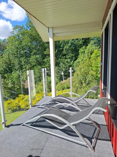 a group of chairs sitting on a porch at Riverside villa in Borlänge