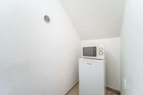a microwave sitting on top of a refrigerator at Pension Family in Karlovy Vary