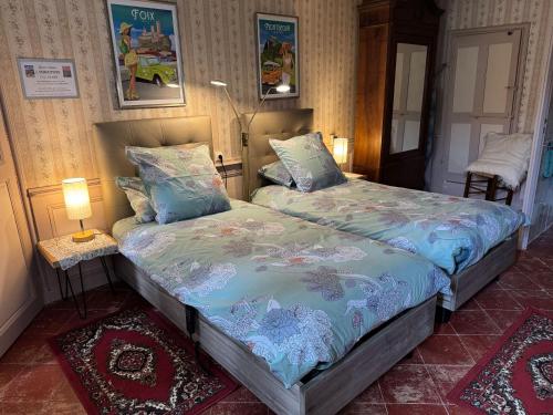 a bedroom with a bed and a table with a lamp at Chambre Lits Jumeaux in Mirepoix