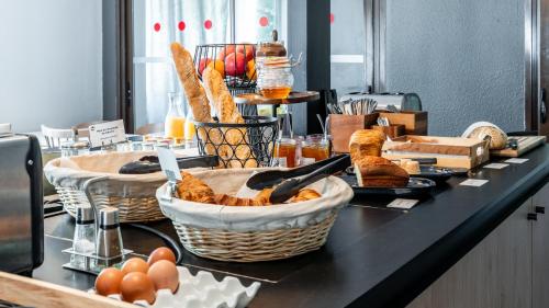 Un buffet con cestas de pan y huevos en un mostrador. en Campanile NATURE - Thionville Yutz, en Basse-Yutz