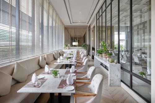 a restaurant with tables and chairs and windows at The Park Nine Hotel Suvarnabhumi - Free BKK Airport Shuttle in Lat Krabang
