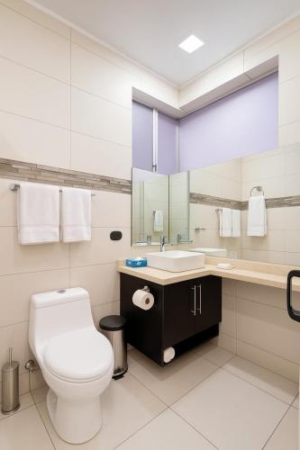 a white bathroom with a toilet and a sink at Costa Rica, San José, Pinares Luxe Apt Near Elite Clinics in San José