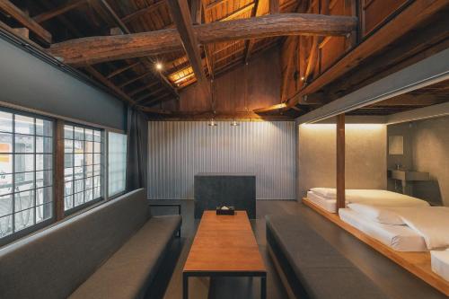 a room with two beds and a table in it at SEKAI HOTEL Deep Osaka Experience in Osaka