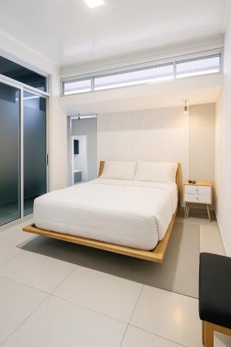 a bedroom with a large bed with white sheets at Costa Rica, San José, Pinares Luxe Apt Near Elite Clinics in San José