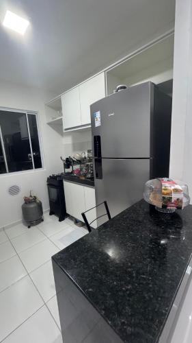 a kitchen with a refrigerator and a black counter top at Condomínio vivendas do Rio 2 in Ananindeua