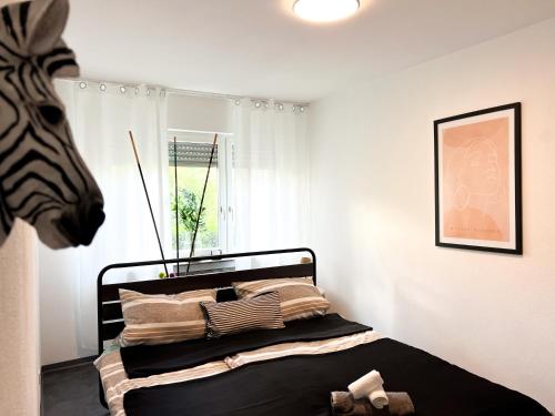 a bedroom with a bed with a zebra head at Helle 2 Zimmer Wohnung mit Balkon gemütlich & zentral in Aalen