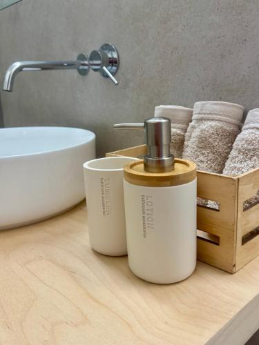 a bathroom counter with two bottles of soap and towels at Serene Coastal Retreat with king Bed & Pool in Lavra in Lavra