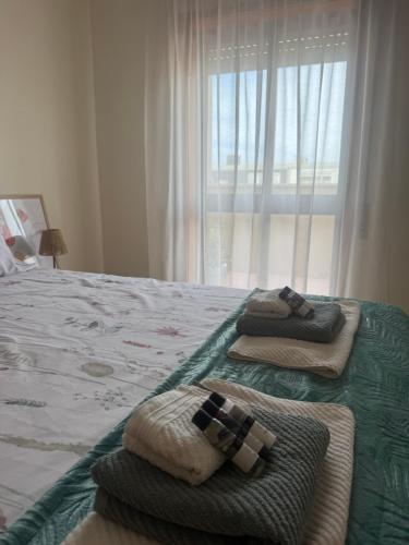 a bedroom with towels on a bed with a window at Serene Coastal Retreat with king Bed & Pool in Lavra in Lavra