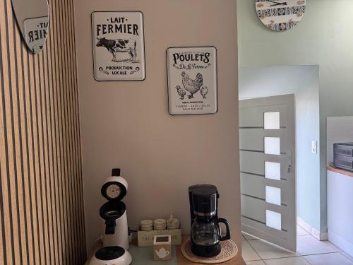 a room with a coffee maker and signs on the wall at Parenthèse romantique avec spa privatif in Deyvillers
