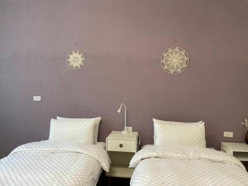 two beds sitting next to each other in a bedroom at 澄居行旅 in Tainan