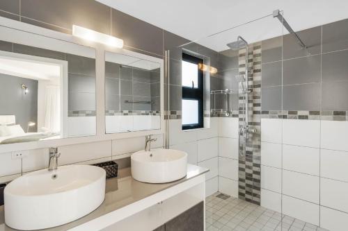 a bathroom with two sinks and a shower at Skyline Azur - Luxueux Penthouse Front de Mer in Flic-en-Flac