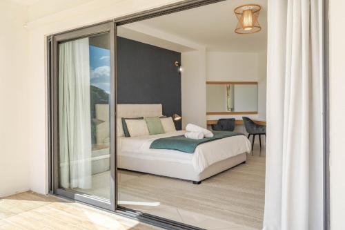 a bedroom with a bed and a sliding glass door at Skyline Azur - Luxueux Penthouse Front de Mer in Flic-en-Flac