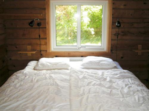 a white bed in a room with a window at 9 person holiday home in HÄLLEVIKSSTRAND-By Traum in Hälleviksstrand