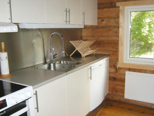 a kitchen with white cabinets and a sink and a window at 9 person holiday home in HÄLLEVIKSSTRAND-By Traum in Hälleviksstrand