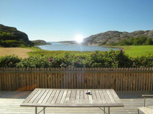 a wooden picnic table with a view of a lake at 9 person holiday home in HÄLLEVIKSSTRAND-By Traum in Hälleviksstrand