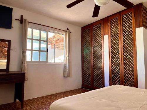 a bedroom with a bed and a window at Beachfront House with Terrace & Bar, AC, 6 Max in Chuburná