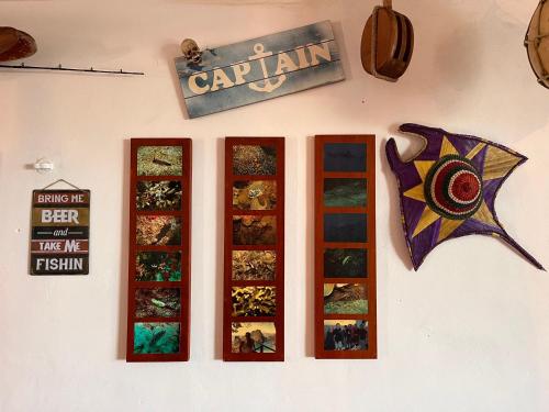 a wall with four windows and a kite on it at Beachfront House with Terrace & Bar, AC, 6 Max in Chuburná