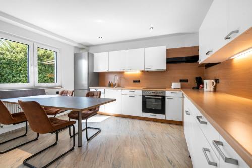 a kitchen with white cabinets and a table and chairs at Die entspannendste Wohnung am Edersee - SPA Sauna in Giflitz