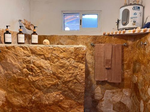 a bathroom with bottles of wine on a counter at Beachfront House with Terrace & Bar, AC, 6 Max in Chuburná