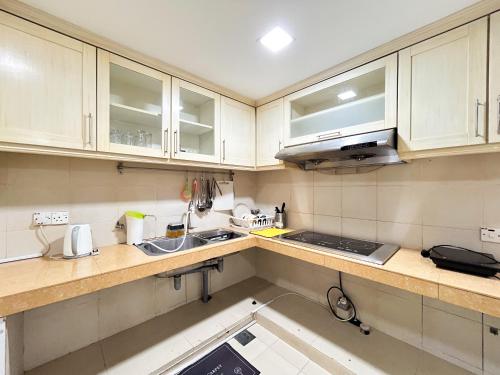 a kitchen with white cabinets and a sink at Gathering Corner House with 6 Rooms upto 16Pax by Manhattan Group in Kuala Lumpur