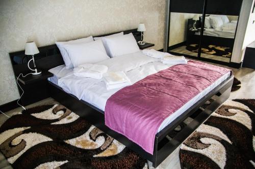 a bedroom with a large bed with a purple blanket at Chalet in Shypyntsi