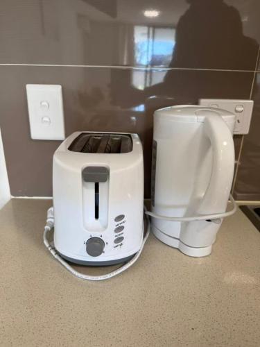 a toaster and a coffee maker on a counter at Parramatta Adorable 3Br Apt ParkingBusShopping in Sydney