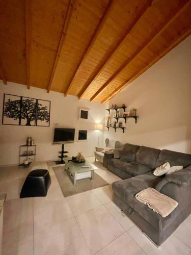 a living room with a couch and a table at Swiss Escape, Chalet with Private Spa & Easy Train Access in Frinvillier