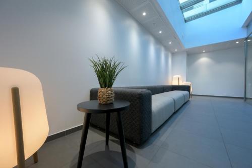 a waiting room with a couch and a table at Nemea Appart Hotel So Cloud Lyon Gare Part-Dieu in Lyon