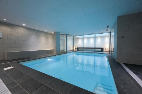 a large swimming pool in a building at Nemea Appart Hotel So Cloud Lyon Gare Part-Dieu in Lyon