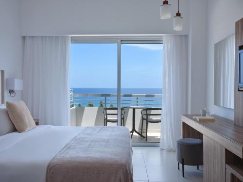 a bedroom with a bed and a view of the ocean at Atlantica Sea Breeze, Adults Only in Protaras