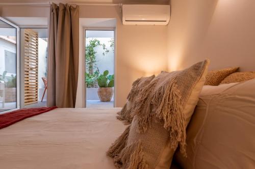 a bedroom with a bed with pillows and a window at Charming Flat with Patio Lisbon in Bicas