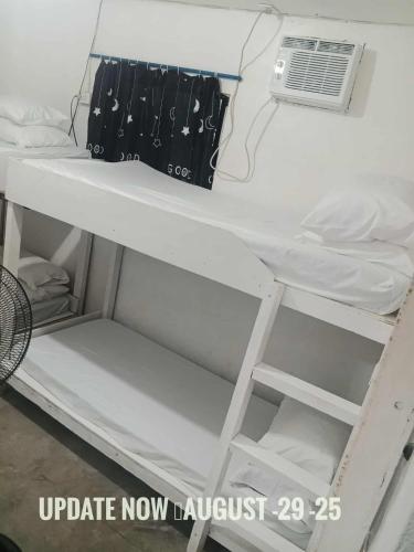 a white bunk bed with a air conditioner on it at Alegreya Homestay + Cafe in General Luna