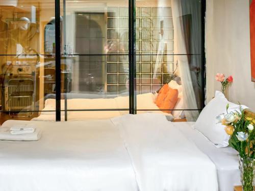 a white bed in a room with a window at Floral Apart mentYongkang Road in Shanghai