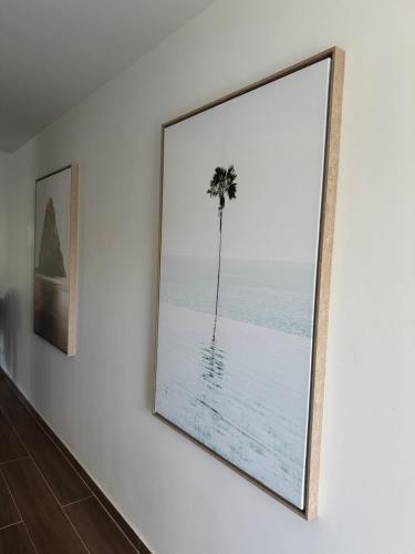 a framed picture of a palm tree on a wall at An Enchanting Break in Saint Martin in Anse Marcel 