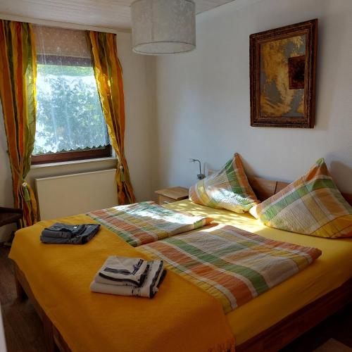 a bedroom with a bed with two towels on it at Haus am Römerstich in Auen