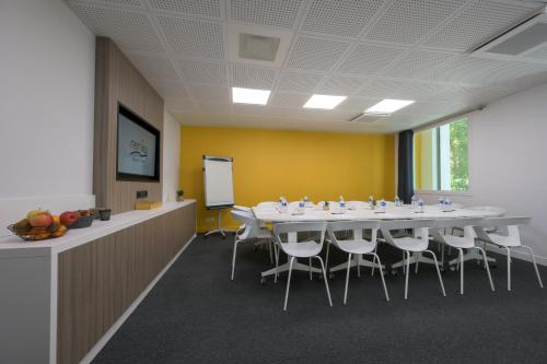 a conference room with a long table and chairs at Nemea Appart Hotel So Cloud Lyon Gare Part-Dieu in Lyon