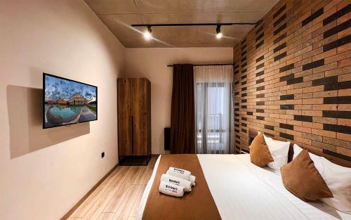 a bedroom with a bed with a brick wall at Rooms Apart Hotel by RED in Yerevan