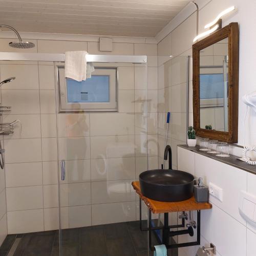 a bathroom with a shower and a sink and a tub at Haus am Römerstich in Auen