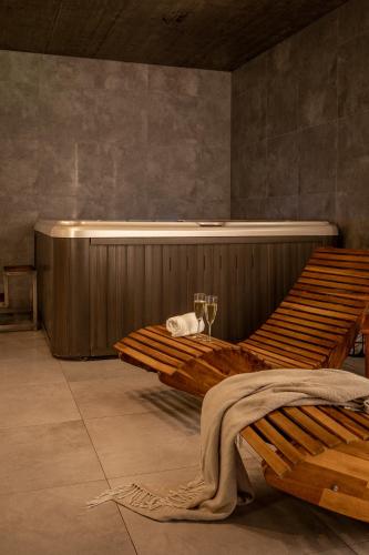 a large wooden bed in a room with a tub at CHATA POD PRZEHYBĄ in Stary Sącz