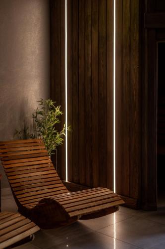 a wooden chair sitting in a room with a plant at CHATA POD PRZEHYBĄ in Stary Sącz