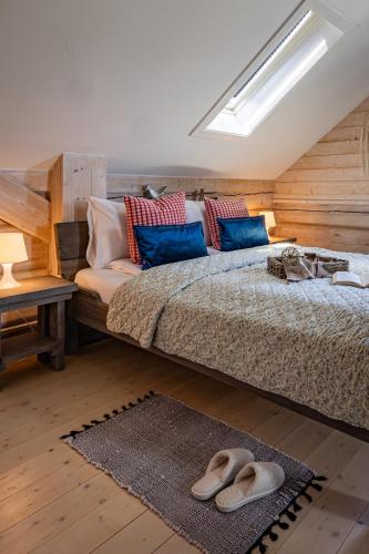 a bedroom with a bed with slippers on the floor at CHATA POD PRZEHYBĄ in Stary Sącz